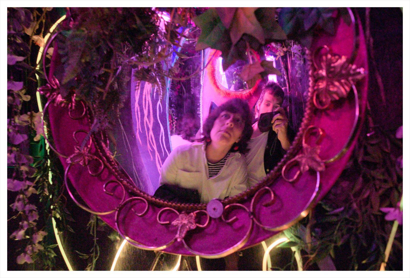 Karen y JP reflejados en un espejo con luces de colores